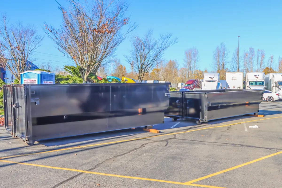 Professional dumpster rental service with roll-off container on residential driveway in Tinton Falls